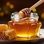 honey dripping from dipper into jar set against wooden tones 11533552591