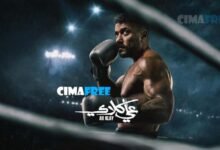 "مشهد درامي متوتر من مسلسل علي كلاي الحلقة 22 يجمع بين الشخصيتين منصور الجوهري وألمظ في مكتب فخم قاتم، يتبادلان نظرات الغضب والمؤامرة بعد علمهما بتنازل العوضي عن الأرض لروح، مع وثائق عقد على المكتب."